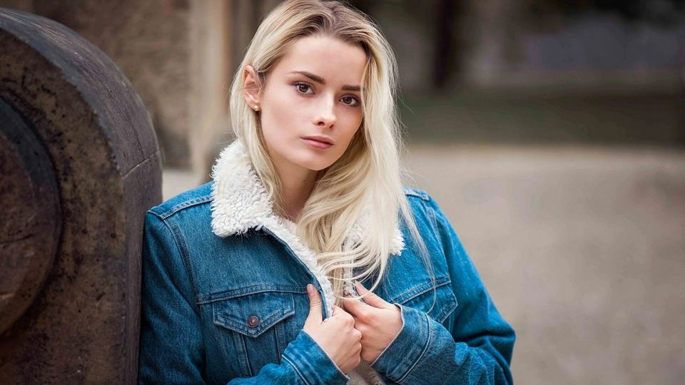 Девушка в Куртке Смотрит на Зрителя