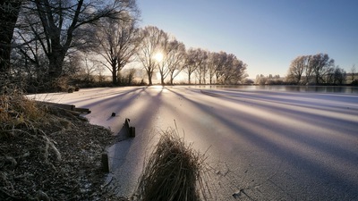 Холодное зимнее замерзшее озеро Солнечные лучи Деревья 4k 5k