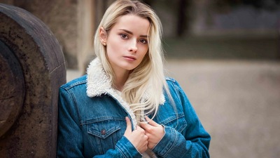 Девушка в Куртке Смотрит на Зрителя